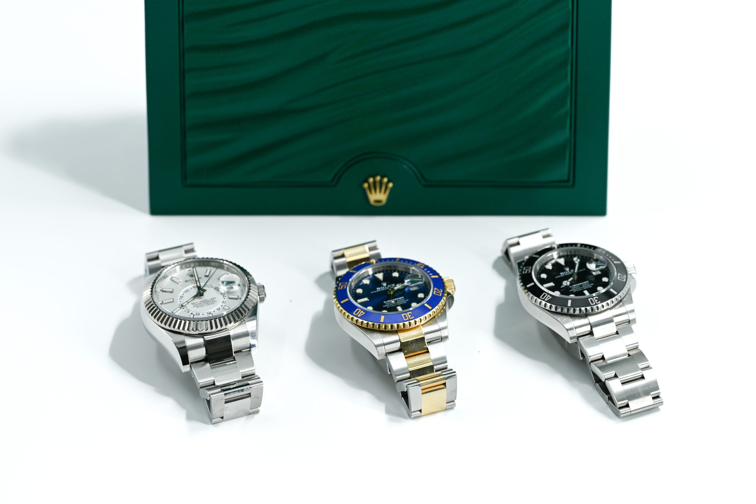 	
Three luxury wristwatches with metal bands are displayed in front of a green box with a gold crown logo, capturing the elegance you’d expect when you Pawn Jewelry Without Receipts in Aventura.