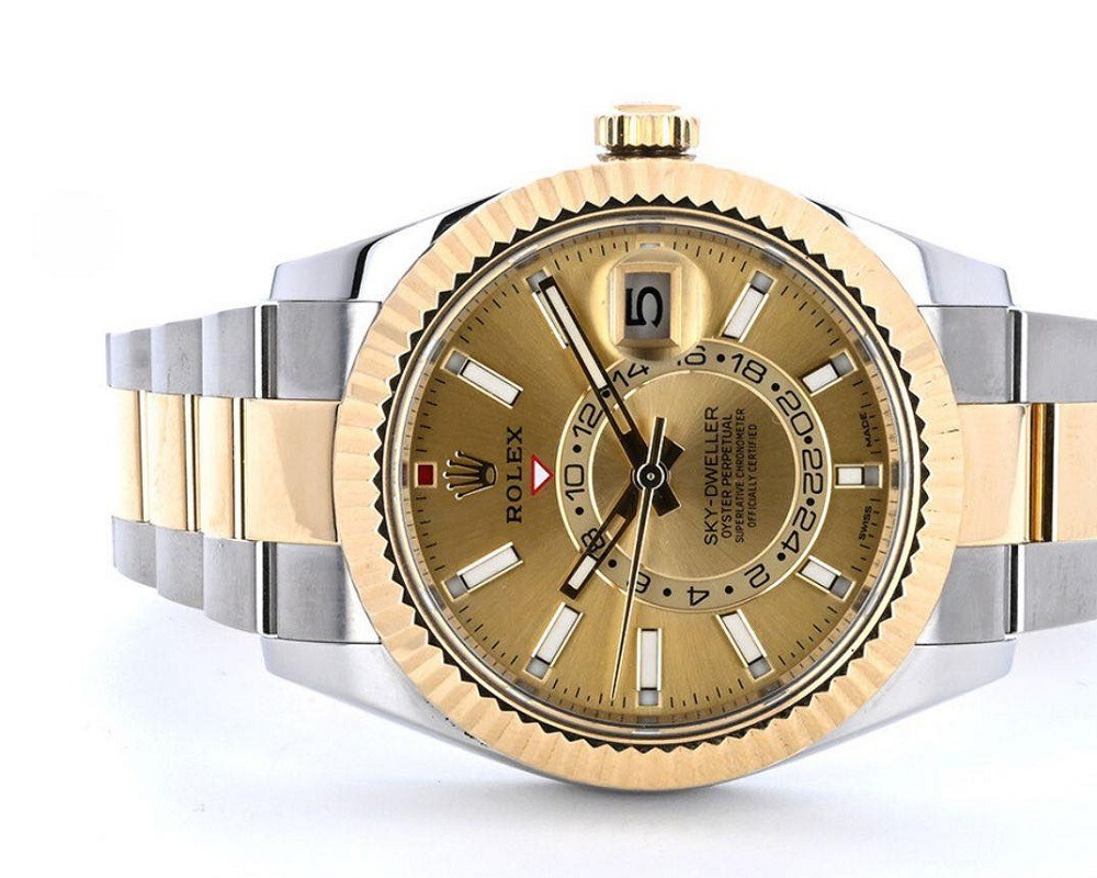 A gold and silver Rolex Sky-Dweller watch with a gold dial, date display, and two-tone bracelet—perfect for those looking to sell a Rolex with aftermarket parts in Atlanta—displayed against a white background.